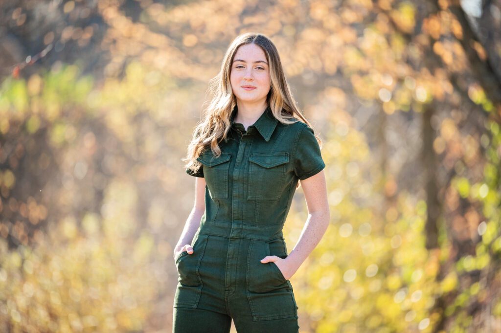 Senior pictures in Edina by Elissa Bean Photography featuring a high school senior in a dark green jumpsuit standing outdoors in warm autumn light.